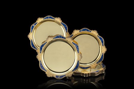 Gruppo di otto sottopiatti in vermeille con bordi polilobati cesellati a volute