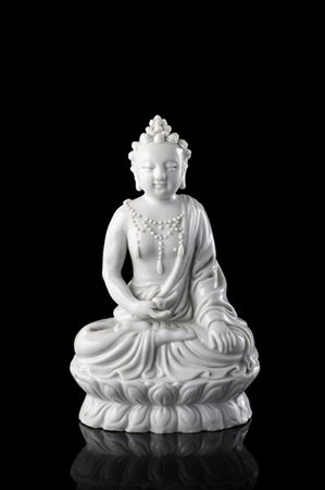 Figura di Bodhisattva in porcellana blanc de chine, in posizione seduta e regge