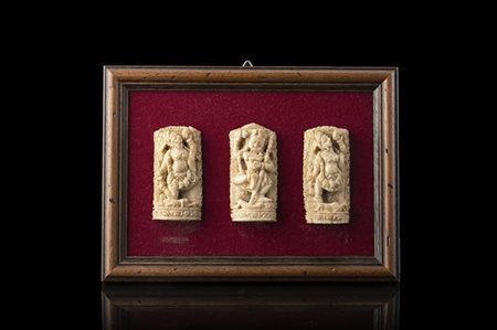 Tre sculture in avorio intagliato raffiguranti Shiva su pannello in velluto, in