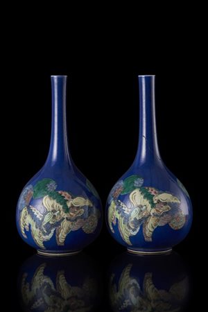 Coppia di vasi a bottiglia in porcellana a fondo blu, decorati a leoni buddhist