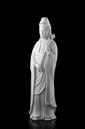 Guanyin in porcellana blanc de chine, in posizione stante e reggente un fiore d
