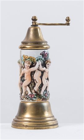 Macinapepe in ottone e ceramica con putti festanti e carillon “O sole mio”....