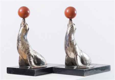 CACCIAPUOTI Coppia di portalibri a forma di foca in terracotta argentata. Sul...