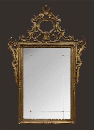 Specchiera in legno intagliato, dorato e traforato a volute e motivi vegetali (