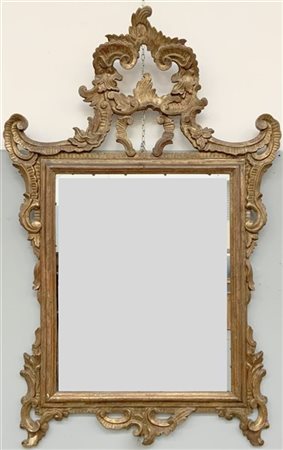 Specchiera in legno intagliato, dorato e traforato, decorata a volute e a motiv