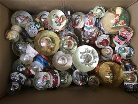 Cartone contenente numerose boules de neige a tema natalizio. Vetro e resina po