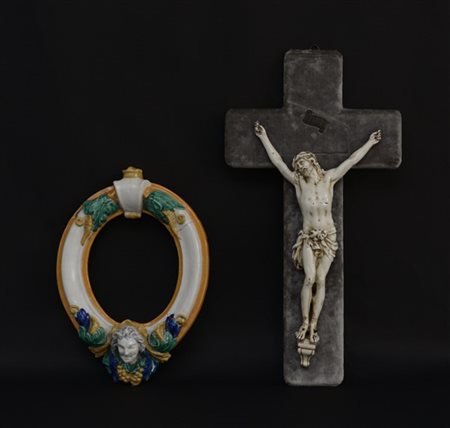 Lotto composto da una cornice ovale in maiolica policroma (h cm 37) ed un crist