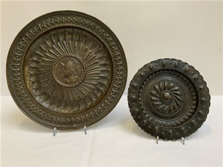 Lotto di due elemosinieri in rame e ottone sbalzato, uno centrato da decoro a u