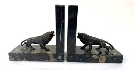 Coppia di fermalibri in marmo nero decorati con figure 
di leoni ruggenti in br