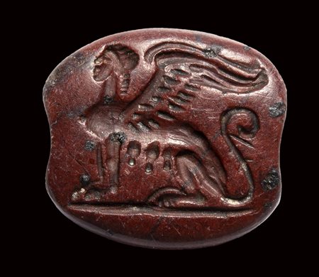 An archaic greek red jasper engraved seal. Seated sphinx. 
