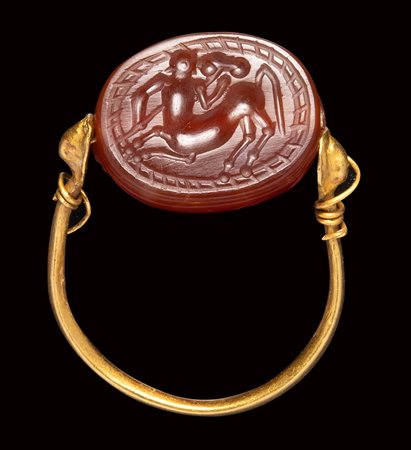 An etruscan carnelian scarab intaglio mounted on an ancient gold ring. Centaur. 