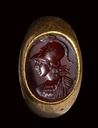 A large roman carnelian intaglio set in a gold ring. Bust of Athena.