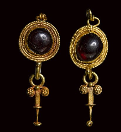 A pair of roman gold earrings set with garnets. 