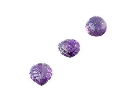 LOTTO DI TRE AMETISTE INTAGLIATE PER CT 122 CIRCA di forma a cuore, rotonda e...