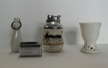 Due accendini un portauovo e una maniglia in porcellana