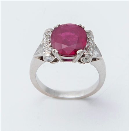 ANELLO CON RUBINO E DIAMANTI in platino, centrato da grande rubino ovale...