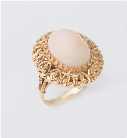 ANELLO IN ORO E CORALLO in oro giallo 18K traforato e inciso, centrato da...