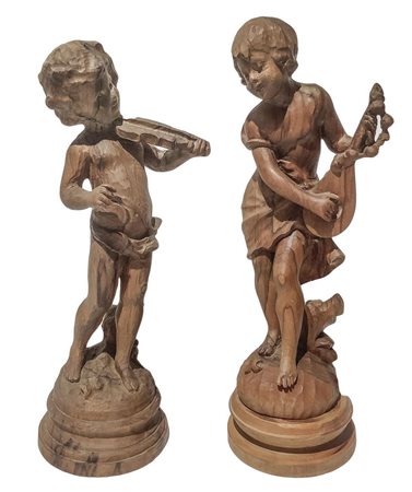 Coppia di sculture in legno raffiguranti bambini musicanti, inizi XX secolo....