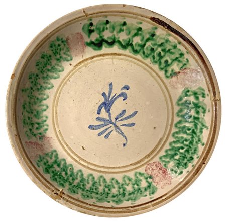Piatto in maiolica di Caltagirone, inizi XX Secolo. Decorato con fiore. Cm 33
