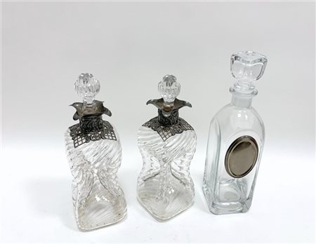 Lotto composto da una coppia di bottiglie in vetro con tappi, corpo costolato e