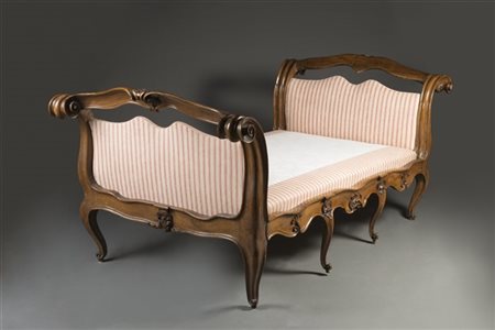 Raro letto in noce con testiera, pediera e montanti mossi e intagliati a motivi