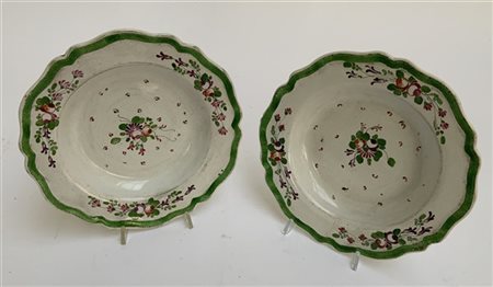 Coppia di fondine in maiolica dipinti in policromia a mazzi di fiori con tese p