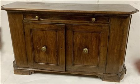 Antica credenza con fronte a due ante e un cassetto e fianchi sagomati. Piedi a
