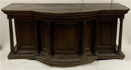 Bancone da negozio in legno di forma mossa con piano sorretto da colonne a tutt