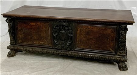 Cassone in legno intagliato e scolpito con zampe ferine, fronte bipartita con c