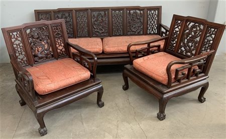 Divano e coppia di poltrone in legno intagliato a motivi geometrici e con dragh