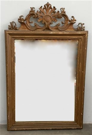 Specchiera in legno dorato ed intagliato, cimasa sagomata e scolpita a conchigl