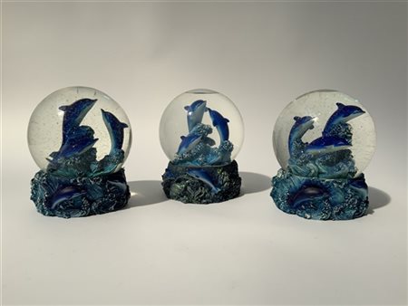 Gruppo di tre boules de neige raffiguranti delfini. Vetro e resina policroma (h