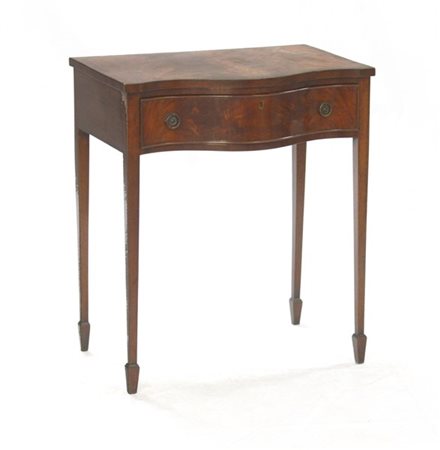 Tavolino ad un cassetto con piano sagomato e lastronato in mogano, gambe rastre