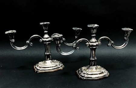 Coppia di candelabri a tre fiamme in lamina d'argento sbalzata su basi in legno