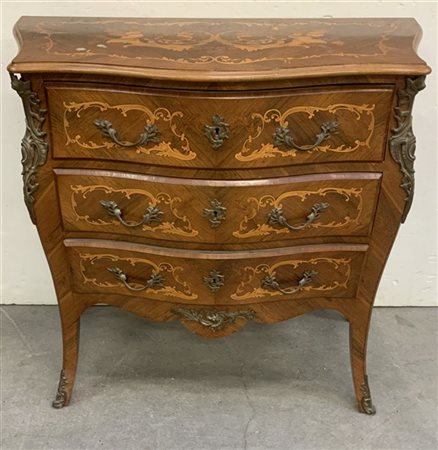 Comò di forma mossa a tre cassetti lastronato e intarsiato a volute e motivi fl