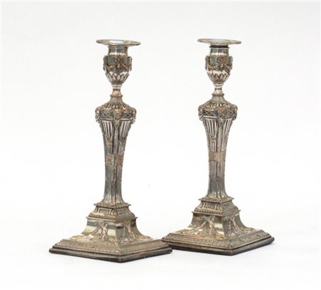 Coppia di candelieri in metallo argentato con fusto a colonna scanalata decorat