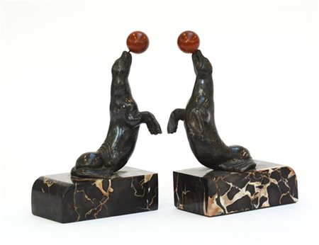 Coppia di fermalibri in lamina di argento decorati a tutto tondo a giochi di fo