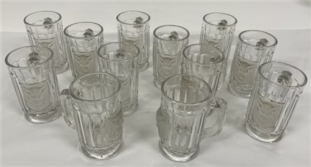 Gruppo di dodici boccali in vetro decorati a testa di ariete a rilievo (difetti