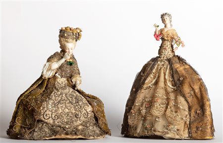 Due bamboline con vesti in tessuto ricamato e corpo in porcellana, secolo XIX