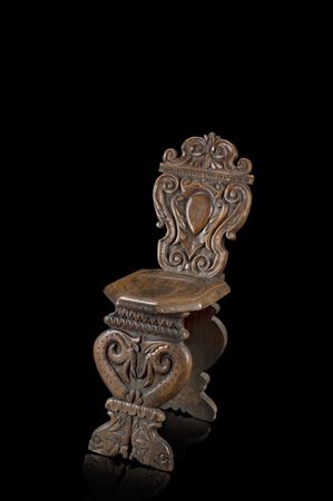 Sgabello in noce intagliato, schienale centrato da stemma tra volute, montanti