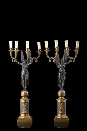Coppia di candelabri in bronzo a quattro fiamme sorretti da figure alate su sfe