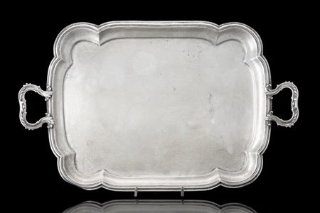 Vassoio biansato in argento di forma sagomata, tesa scanalata e anse decorate a