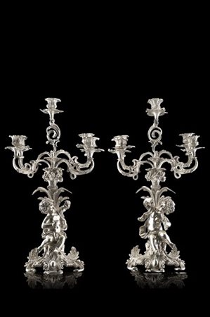 Coppia di candelieri a cinque fiamme in argento Fusti con putti baccanti e suon