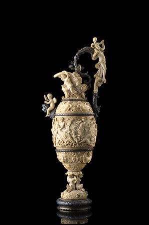 Acquamanile in avorio scolpito, versatoio estroflesso sostenuto da una coppia d