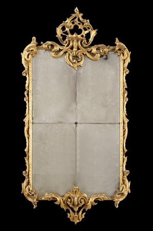 Specchiera in legno intagliato e dorato, con cimasa traforata e decorata a volu