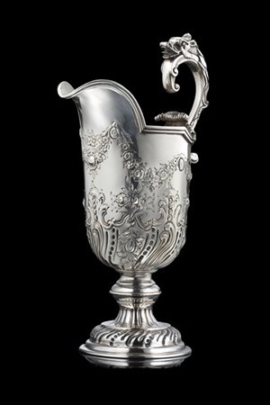 Versatoio in argento sbalzato a festoni, fiori e foglie, ansa a voluta e animal