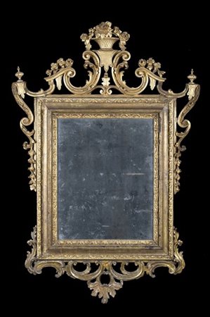 Specchiera in legno intagliato e dorato a motivi vegetali, fregi traforati a vo