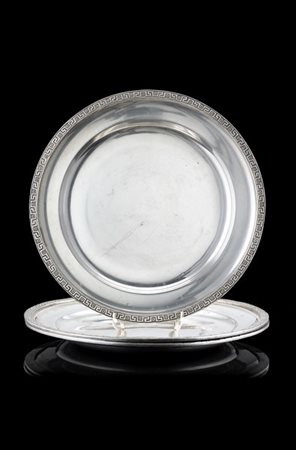 Gruppo di tre piatti in argento liscio con tesa decorata a greca classica e med
