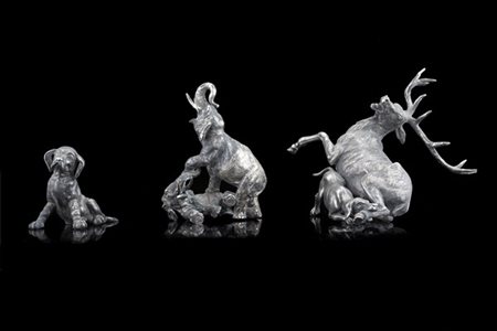 Lotto composto da tre sculture in argento raffiguranti un cervo azzannato da un