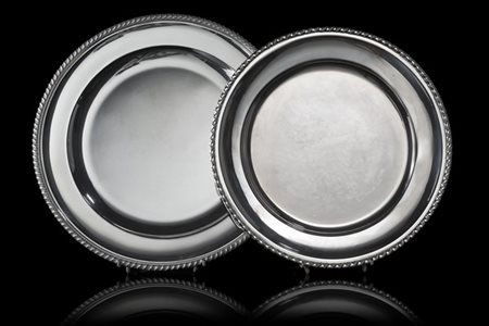 Lotto composto da due piatti in argento a corpo liscio con bordo cordonato. Tit